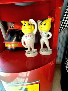 Figurines de collection Esso (gouttes mascottes) exposées avec un casque de moto vintage, déco collector chambre Pole Position