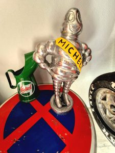 Table conçue avec un panneau routier, décorée d’un Bibendum en métal et d’une cruche vintage Castrol, esprit mécanique et rétro