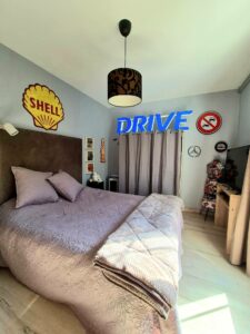 Vue d’ensemble de la chambre Pole Position avec lit 160 cm confortable, déco inspirée de l’univers automobile